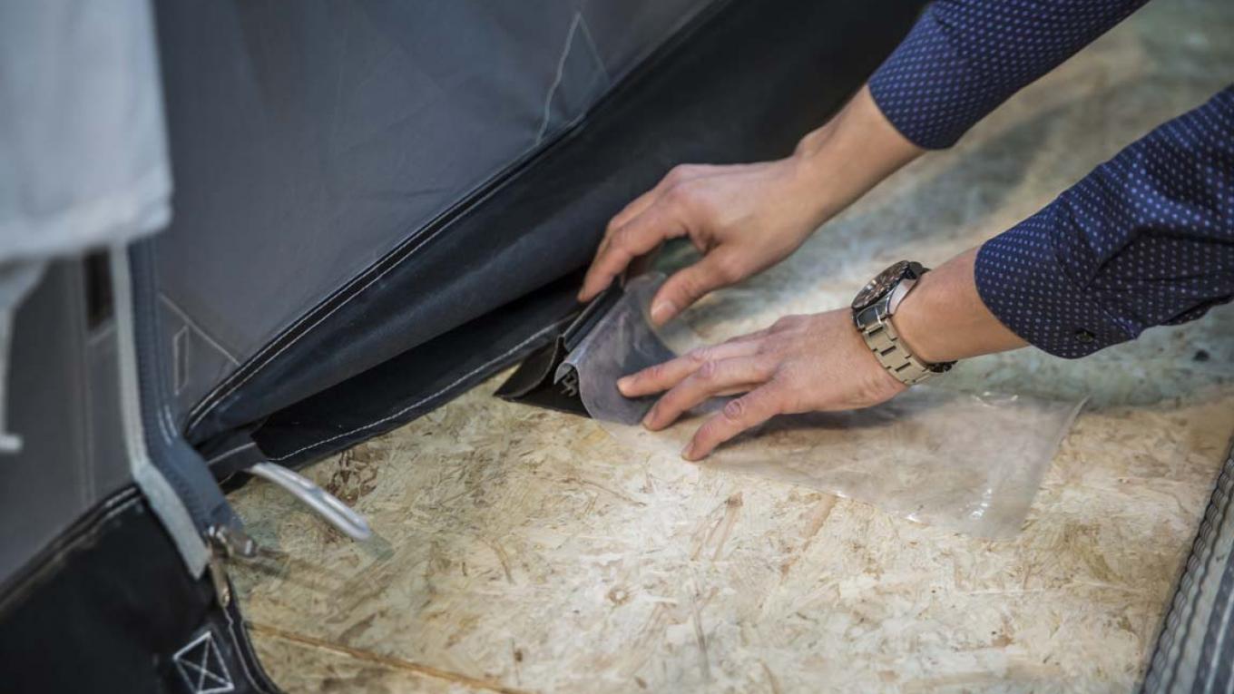 Plastikfolien sættes ind i slidsen på Vandstopperen, så forteltet får en fast bund. Dermed løber regnvandet uden om eller under forteltet. vandstopperen, campingudstyr, smart opfindelse
